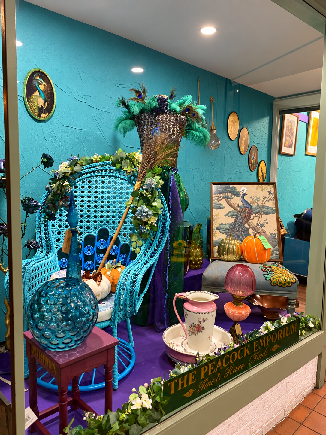 A colourful Peacock Emporium display featuring peacock-inspired furniture and vintage finds